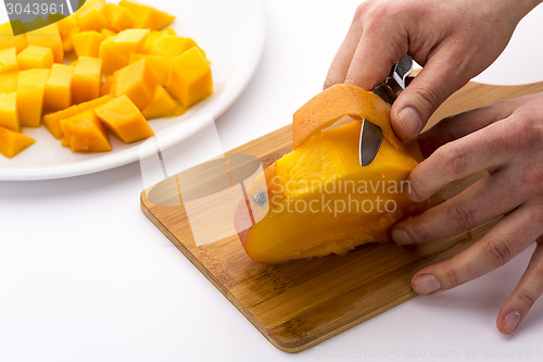Image of Peeling The Mango Slice Containing The Fruit Pit