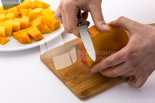 Image of Peeling The Middle Mango Slice With The Fruit Pit