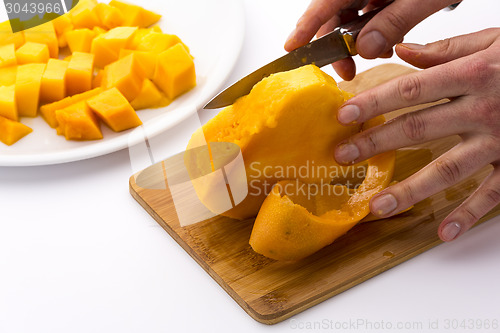 Image of Middle Third Of A Mango With Its Pit Being Peeled