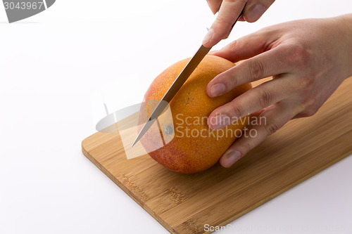 Image of Knife In Position For A First Cut Through A Mango