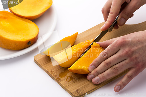 Image of Mango Divided Into Thirds Being Subdivided Further