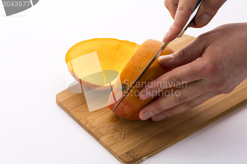 Image of Knife Positioned For A Second Cut Through A Mango