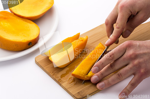 Image of Mango Slice Being Cut Into Four Fruit Chips