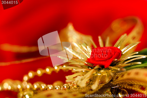 Image of golden decoration on red fabric. macro