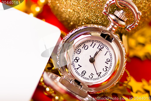 Image of Christmas card. Silver vintage watch on a red background with go