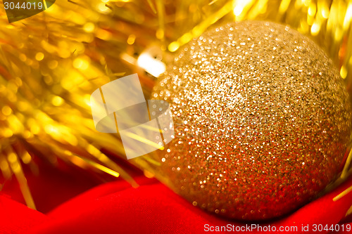 Image of Christmas golden ball and tinsel on red. macro