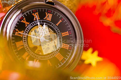 Image of Christmas card. vintage watch on a red background with golden de