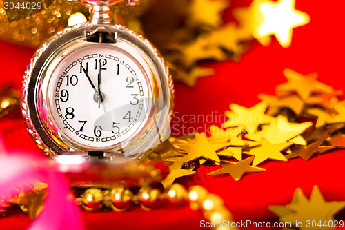 Image of Christmas card. Silver vintage watch on a red background with go