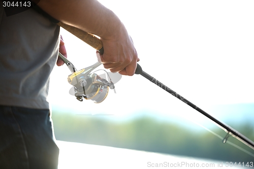 Image of Modern clean fishing rod in hands