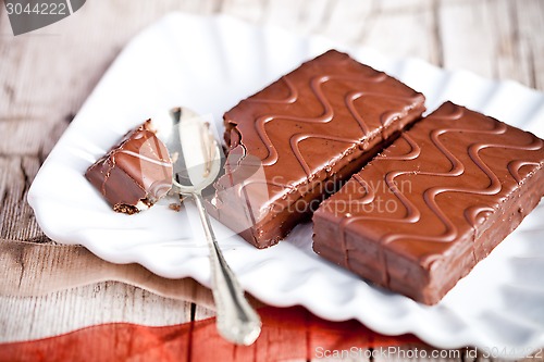 Image of dark chocolate cakes and spoon on a plate 