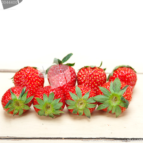 Image of fresh organic strawberry over white wood
