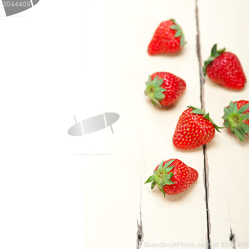 Image of fresh organic strawberry over white wood