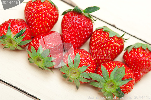 Image of fresh organic strawberry over white wood