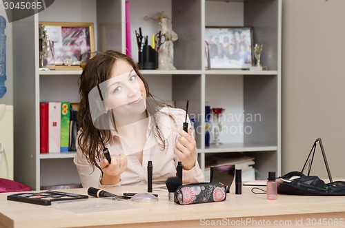 Image of Girl in the office chooses to make up some mascara eyelashes