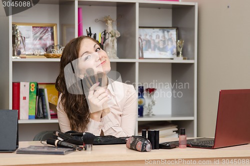 Image of Girl in the office with brushes for make-up