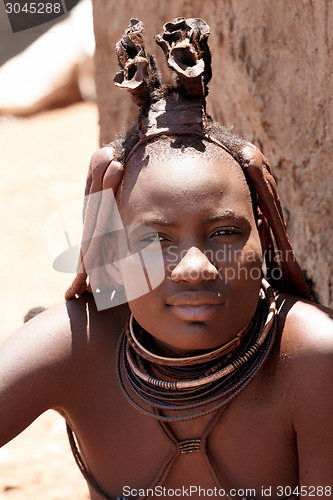 Image of Himba woman with ornaments on the neck in the village