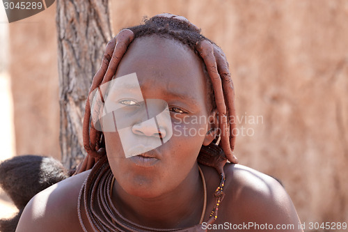 Image of Himba woman with ornaments on the neck in the village
