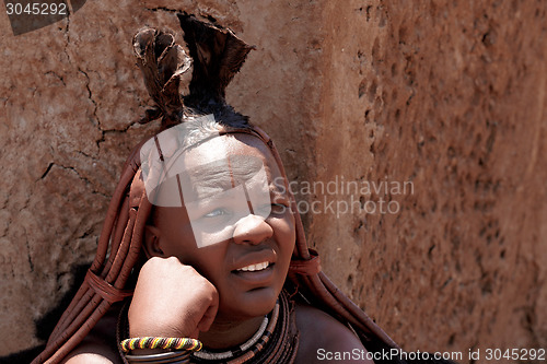 Image of Himba woman with ornaments on the neck in the village