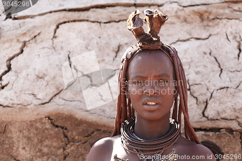 Image of Himba woman with ornaments on the neck in the village