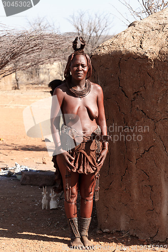 Image of Himba woman with ornaments on the neck in the village