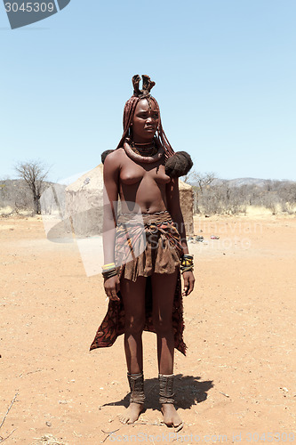Image of Himba woman with ornaments on the neck in the village
