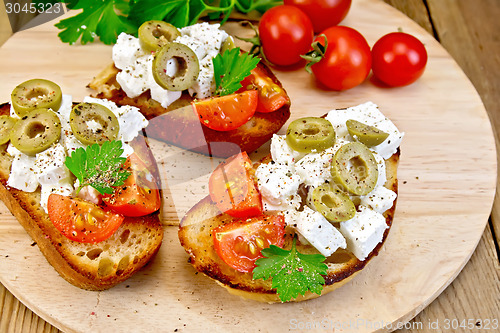 Image of Sandwich with feta and olives on round board