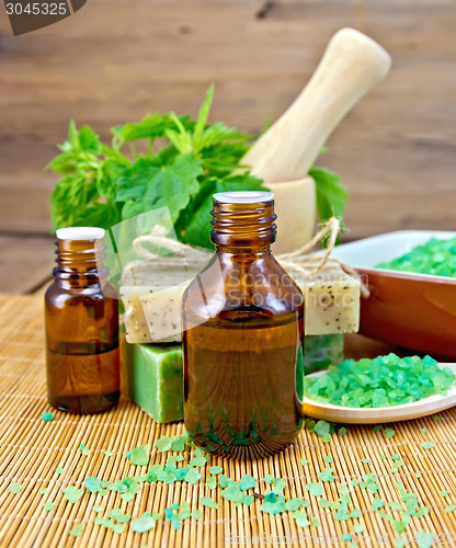 Image of Oil and soap with nettles in mortar on board