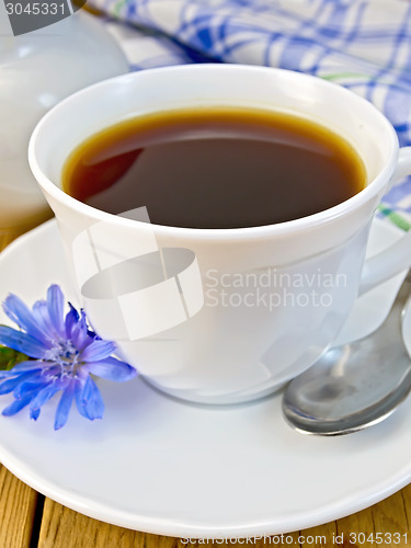 Image of Chicory drink in white cup with milkman and flower on board