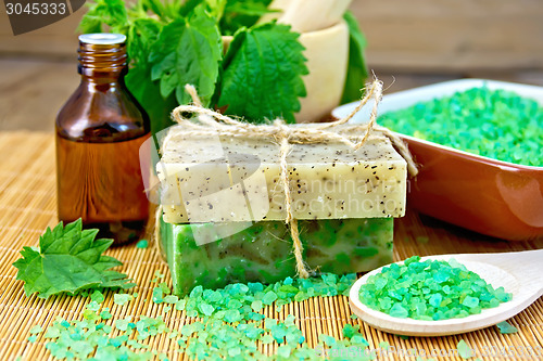 Image of Soap homemade and oil with nettles in mortar on board