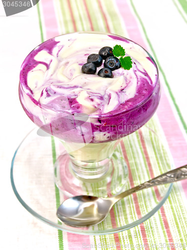 Image of Dessert milk with blueberries on striped tablecloth