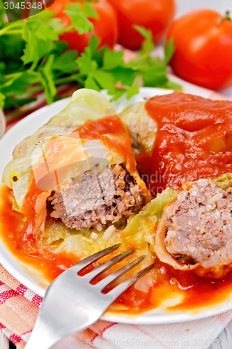 Image of Cabbage stuffed with fork in plate on board