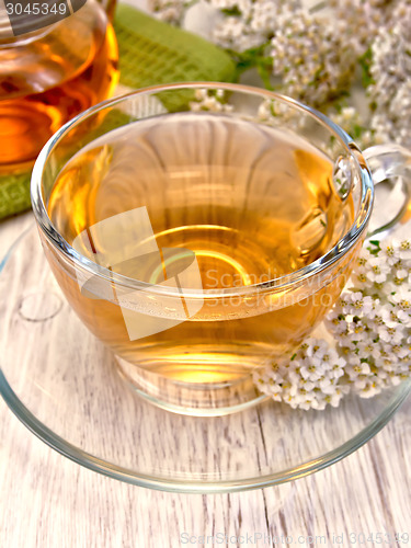 Image of Tea with yarrow in glass cup on board