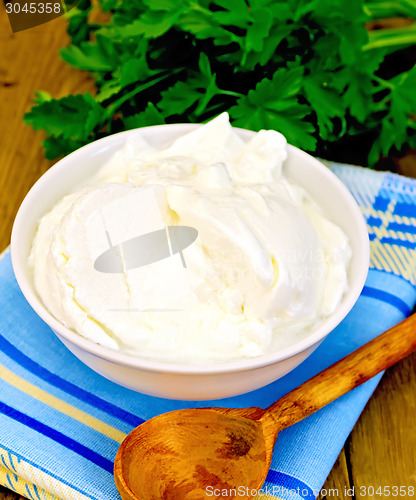 Image of Yogurt in white bowl with greens on board