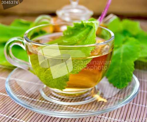 Image of Tea with sage in cup on bamboo napkin