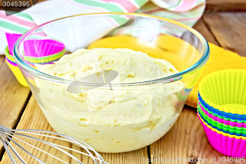 Image of Dough for cupcakes with molds on board