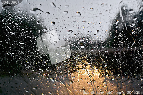 Image of Raindrops with yellow car headlights