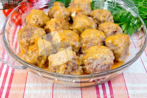 Image of Meatballs with sauce in glass pan on linen tablecloth