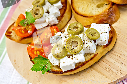 Image of Sandwich with feta and olives on napkin