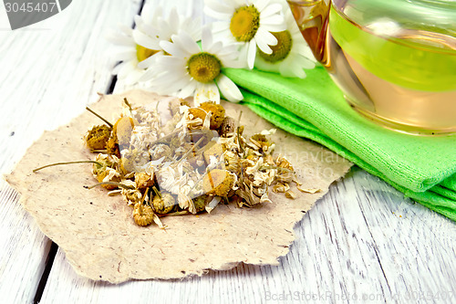 Image of Chamomile dried on paper with glass teapot