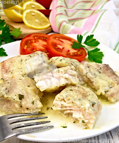 Image of Fish stew in creamy sauce with tomatoes in plate on board