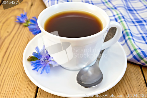 Image of Chicory drink in white cup with flower and napkin on board