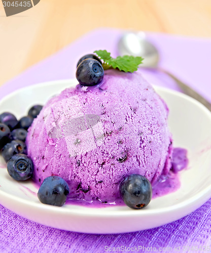 Image of Ice cream blueberry with mint in dish on napkin