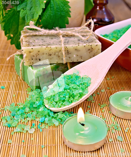 Image of Salt and candles with nettles in mortar on board