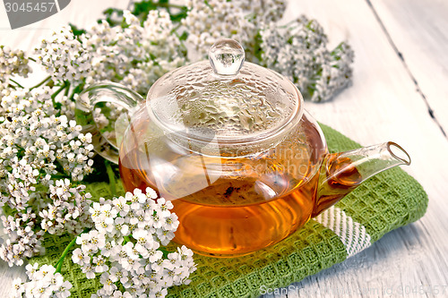 Image of Tea with yarrow in glass teapot on napkin