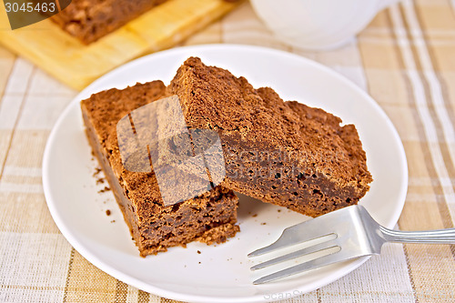 Image of Pie chocolate in plate with fork on tablecloth