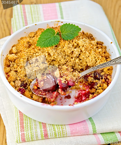 Image of Crumble cherry in bowl with spoon on napkin