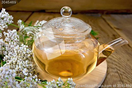 Image of Tea with yarrow in glass teapot on board