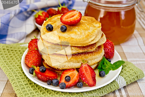 Image of Flapjacks with strawberries and blueberries with napkin