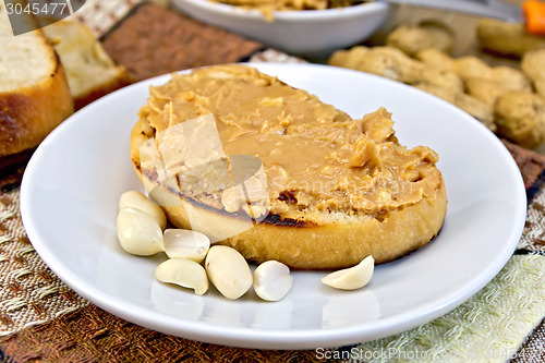 Image of Sandwich with peanut butter and nuts in bowl on napkin