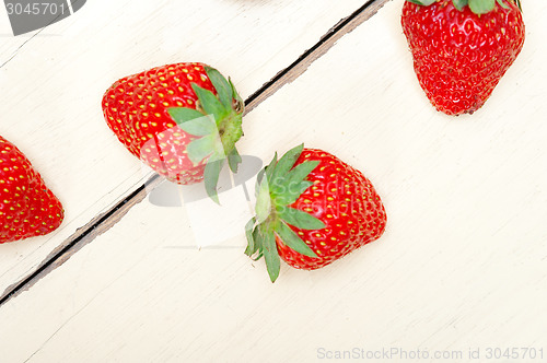 Image of fresh organic strawberry over white wood